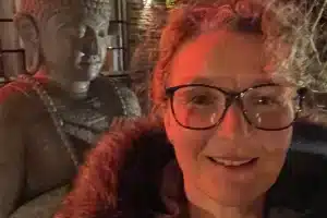 Kirsty standing in front of a buddha statue