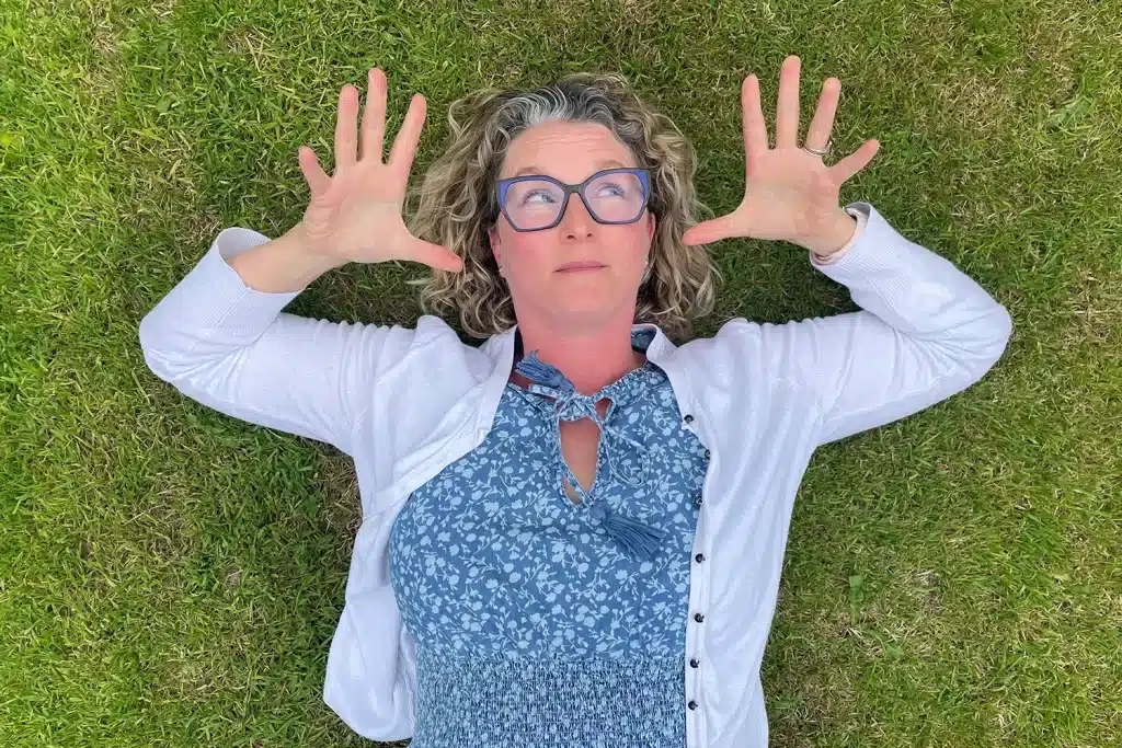 Kirsty Heap lying in the grass with her hands beside her head.